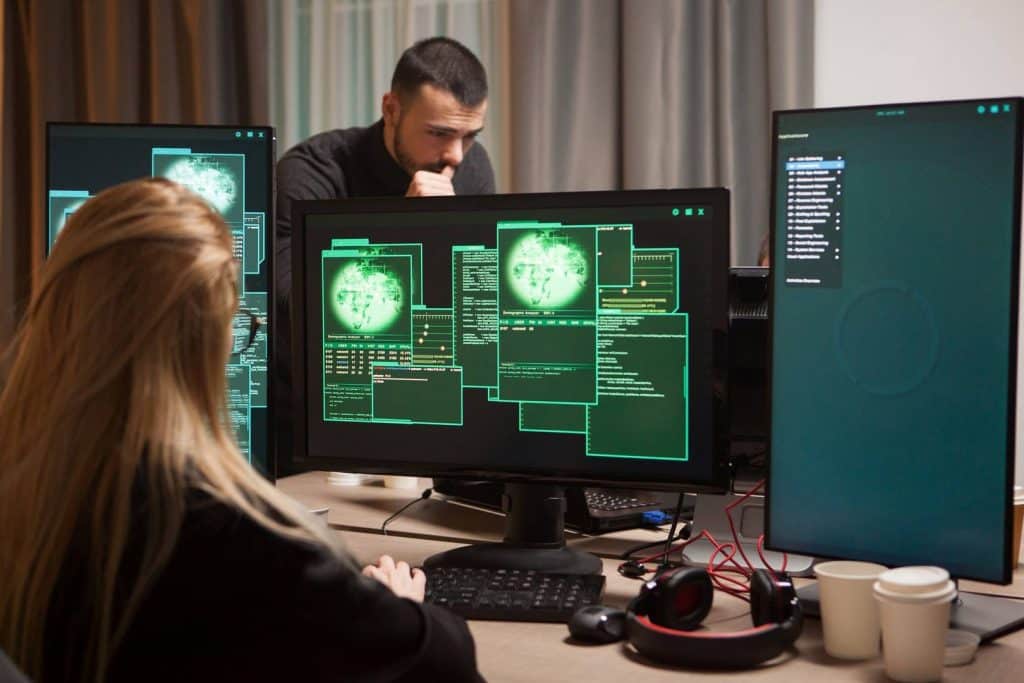 Vista posterior del virus de escritura de hacker femenina en la computadora. hacker masculino en el fondo.
